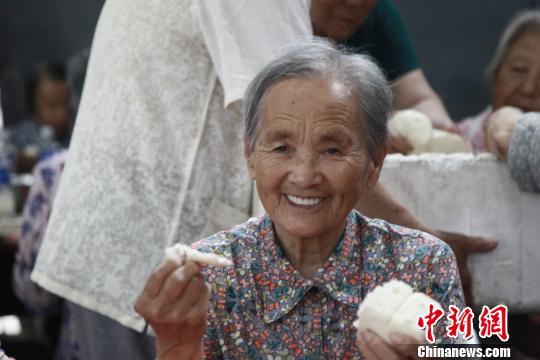 老人们喜笑颜开的吃着大锅菜，跟邻里唠着家常。　李院红 摄